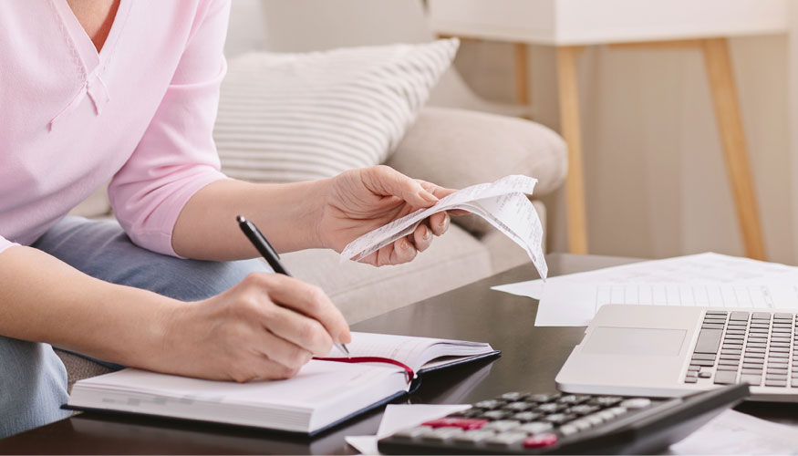Senior woman bookkeeping bills and payments at home